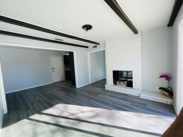 unfurnished living room with a fireplace, beam ceiling, and dark wood-type flooring