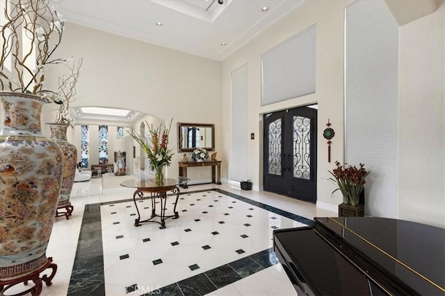 tiled entryway with french doors and a high ceiling