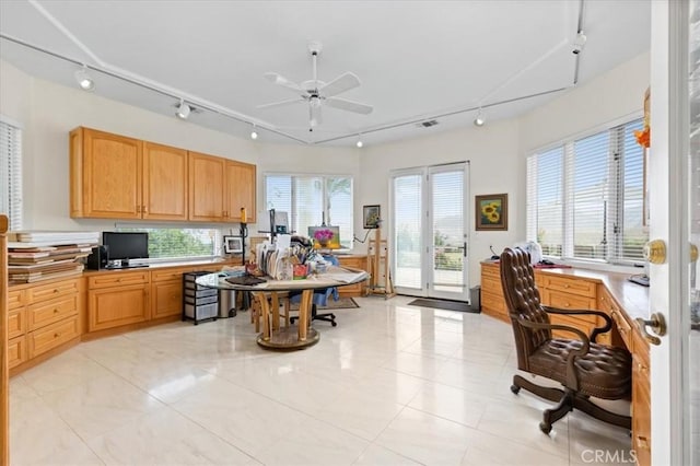 kitchen featuring a healthy amount of sunlight, built in desk, and ceiling fan