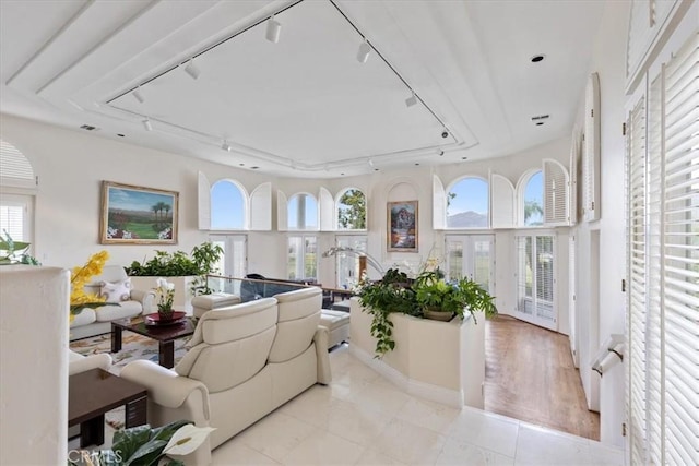 living room with rail lighting and light tile patterned floors