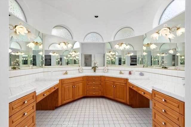 bathroom with a towering ceiling, vanity, and backsplash