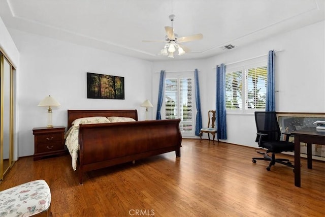 bedroom with ceiling fan, wood-type flooring, and a closet