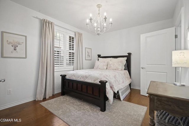 bedroom with dark hardwood / wood-style floors and a notable chandelier