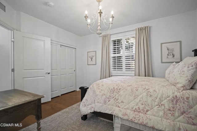 bedroom featuring a notable chandelier, dark hardwood / wood-style flooring, and a closet