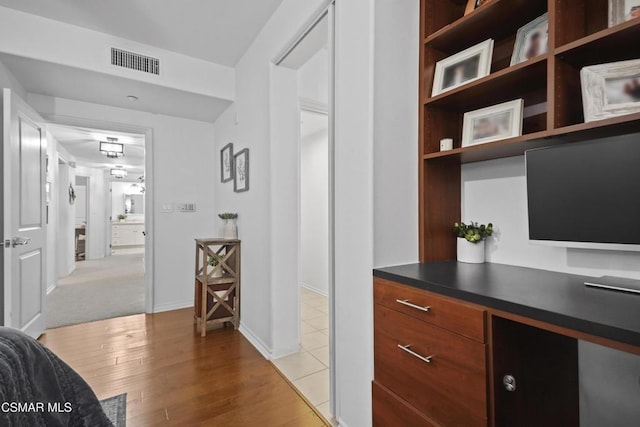 hallway with light hardwood / wood-style floors