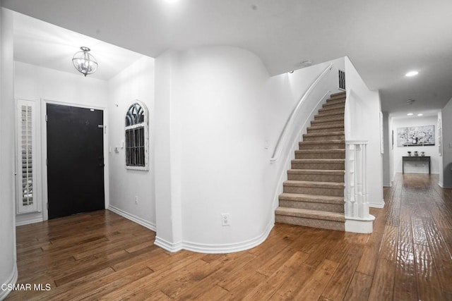 foyer entrance with dark hardwood / wood-style floors and a notable chandelier