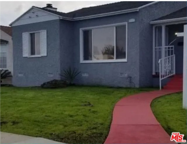 view of side of home with a yard