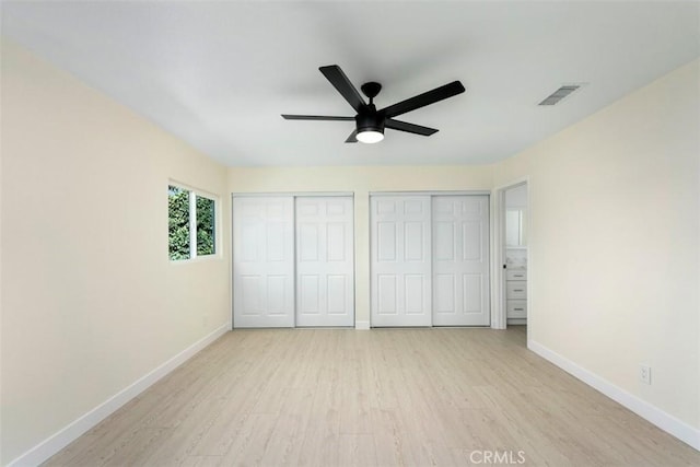 unfurnished bedroom featuring multiple closets, ceiling fan, and light hardwood / wood-style floors