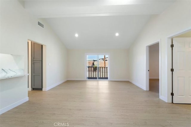 unfurnished room featuring vaulted ceiling with beams and light hardwood / wood-style flooring