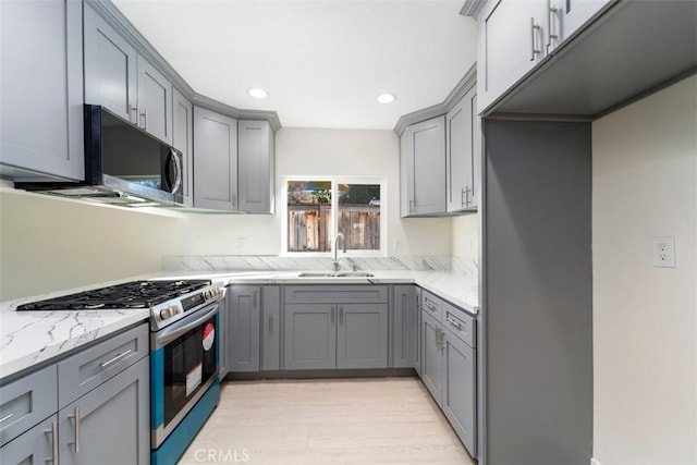 kitchen featuring gray cabinets, sink, and stainless steel gas range