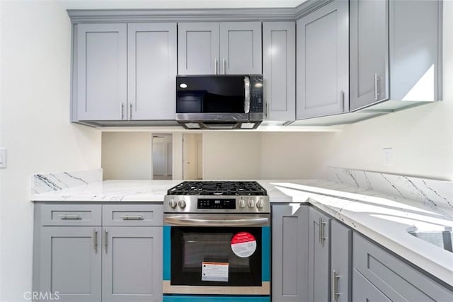 kitchen featuring appliances with stainless steel finishes, gray cabinets, and light stone countertops