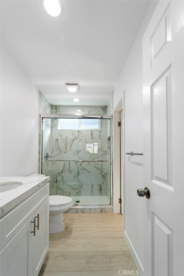 bathroom with vanity, toilet, and an enclosed shower