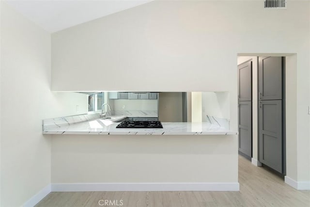 kitchen with sink, gray cabinets, kitchen peninsula, and black gas cooktop