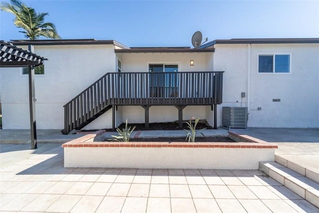 rear view of property featuring cooling unit, a pergola, and a patio area