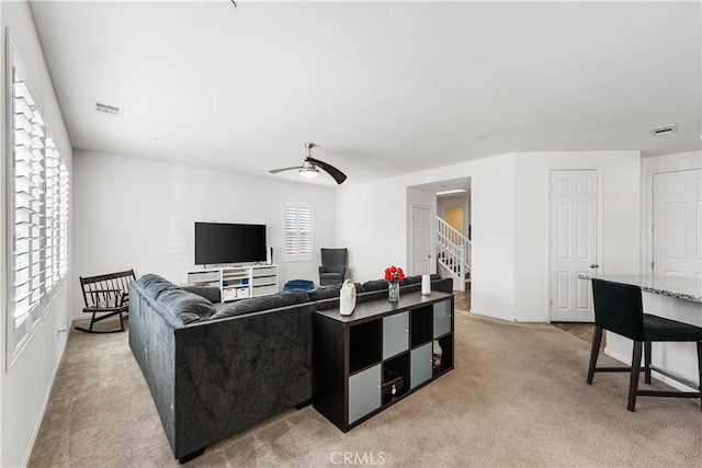 living room with ceiling fan and light colored carpet