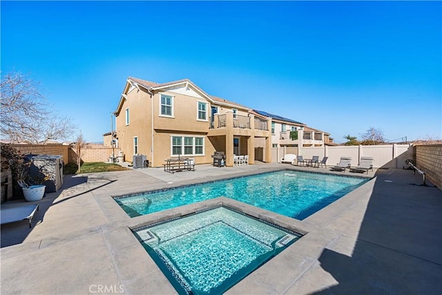 view of pool with an in ground hot tub, cooling unit, and a patio