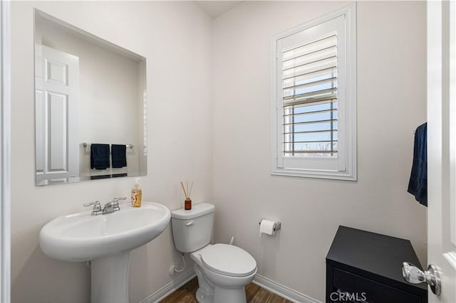 bathroom featuring wood-type flooring, toilet, and sink