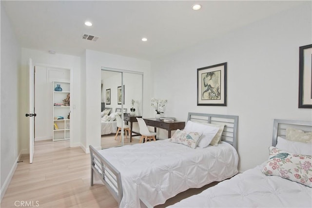 bedroom with light hardwood / wood-style floors and a closet