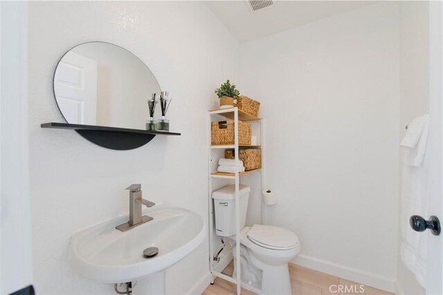 bathroom featuring toilet, tile patterned flooring, and sink