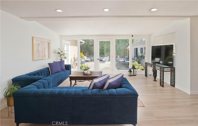 living room with light wood-type flooring and vaulted ceiling with beams