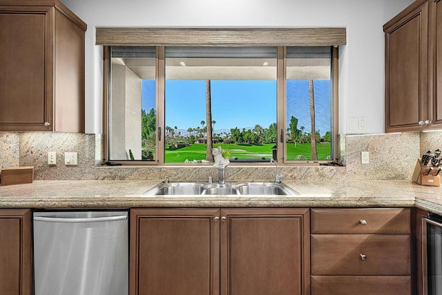 kitchen with tasteful backsplash, light stone countertops, sink, and stainless steel dishwasher