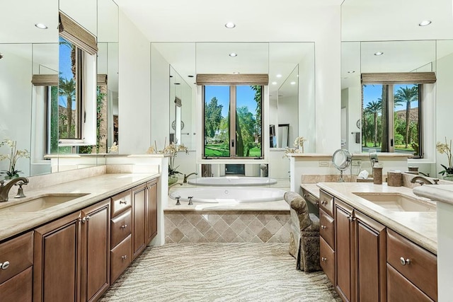 bathroom featuring tiled tub and vanity