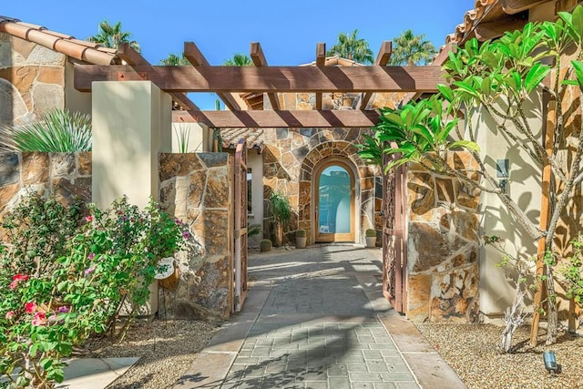 view of exterior entry featuring a pergola