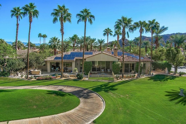 back of property with a patio, a mountain view, and a yard