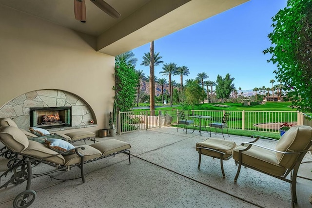 view of patio featuring ceiling fan and an outdoor stone fireplace