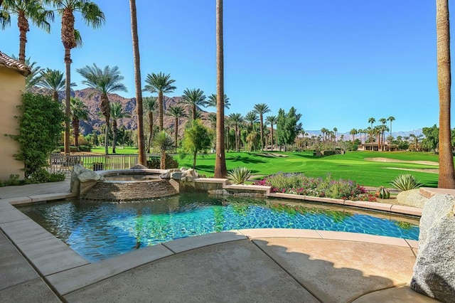 view of pool featuring an in ground hot tub, a mountain view, and a lawn