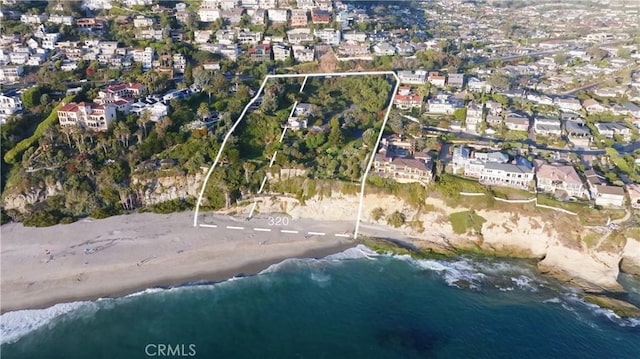 birds eye view of property with a water view and a beach view