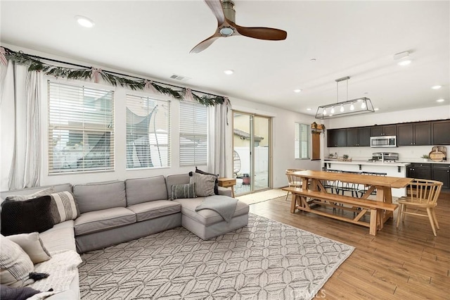 living room featuring ceiling fan and light wood-type flooring