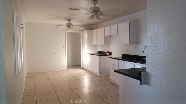 kitchen with ceiling fan, white cabinets, and light tile patterned flooring