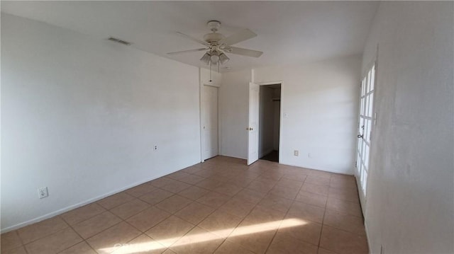 empty room featuring light tile patterned floors and ceiling fan