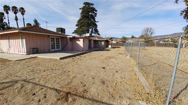 rear view of property featuring central AC unit and a patio