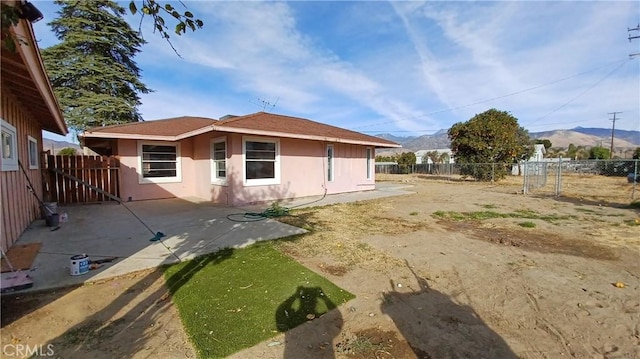 rear view of house with a mountain view and a patio area