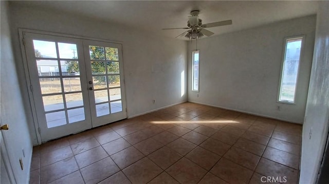 empty room with french doors, ceiling fan, and tile patterned floors