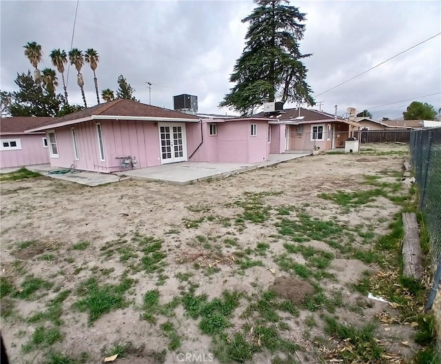 rear view of house featuring french doors, central AC unit, a patio area, and fence