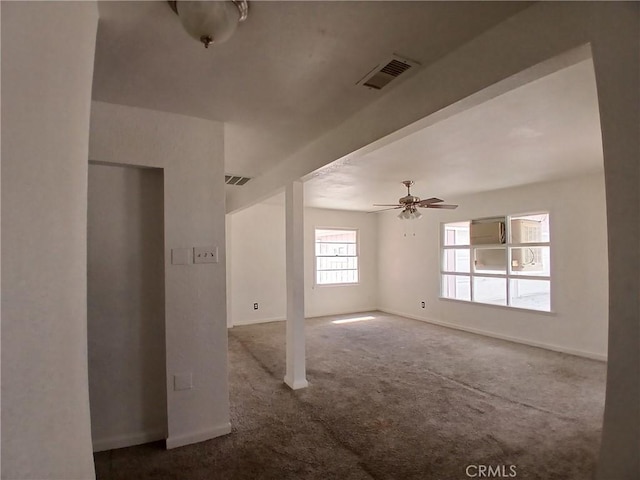 carpeted spare room featuring a ceiling fan, visible vents, and baseboards