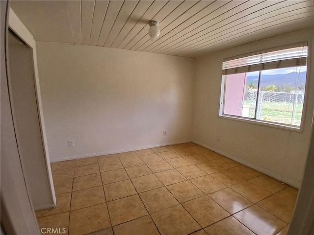 unfurnished room featuring wooden ceiling and light tile patterned floors