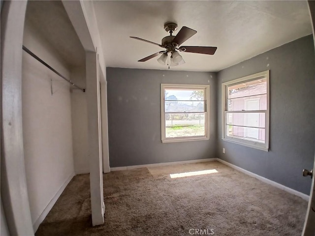 unfurnished bedroom featuring carpet, baseboards, and ceiling fan