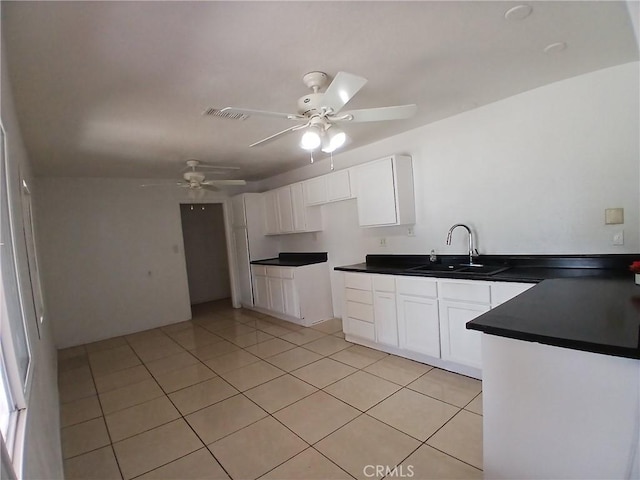 kitchen with white cabinets, a sink, and light tile patterned floors