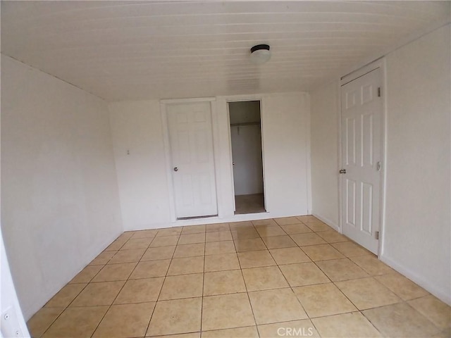 unfurnished bedroom with light tile patterned floors and a closet