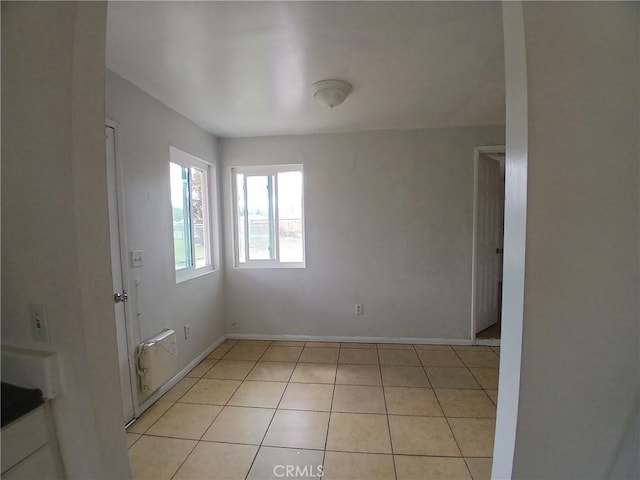 spare room with light tile patterned flooring and baseboards