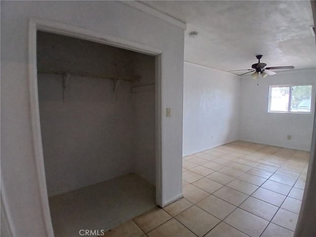 unfurnished bedroom featuring light tile patterned floors, a closet, and a ceiling fan