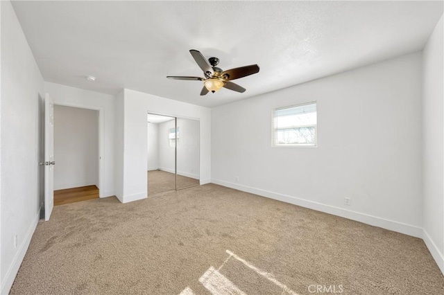 unfurnished bedroom featuring ceiling fan, carpet, and a closet