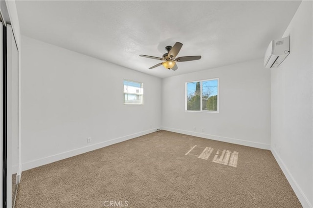 spare room featuring ceiling fan, carpet floors, and an AC wall unit