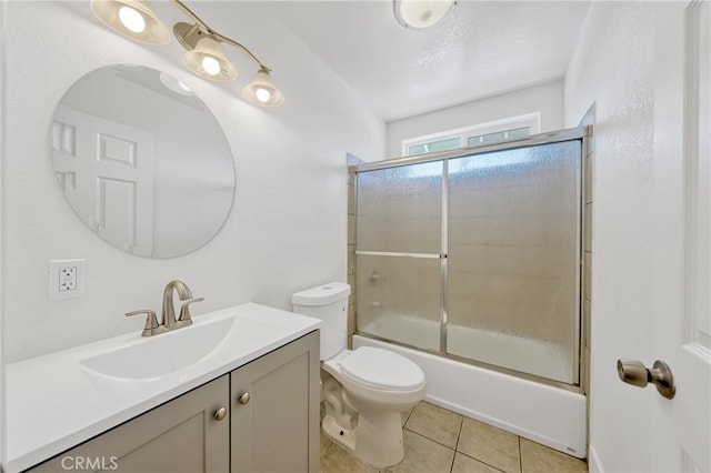 full bathroom with vanity, tile patterned flooring, shower / bath combination with glass door, and toilet