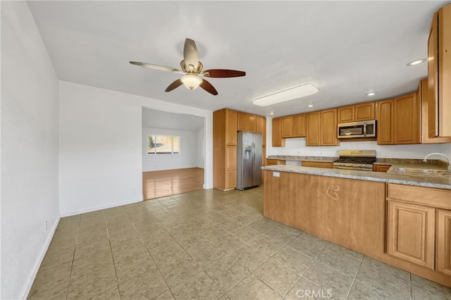 kitchen with stainless steel appliances, sink, and ceiling fan