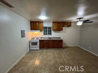 kitchen featuring ceiling fan, white range with gas cooktop, and sink